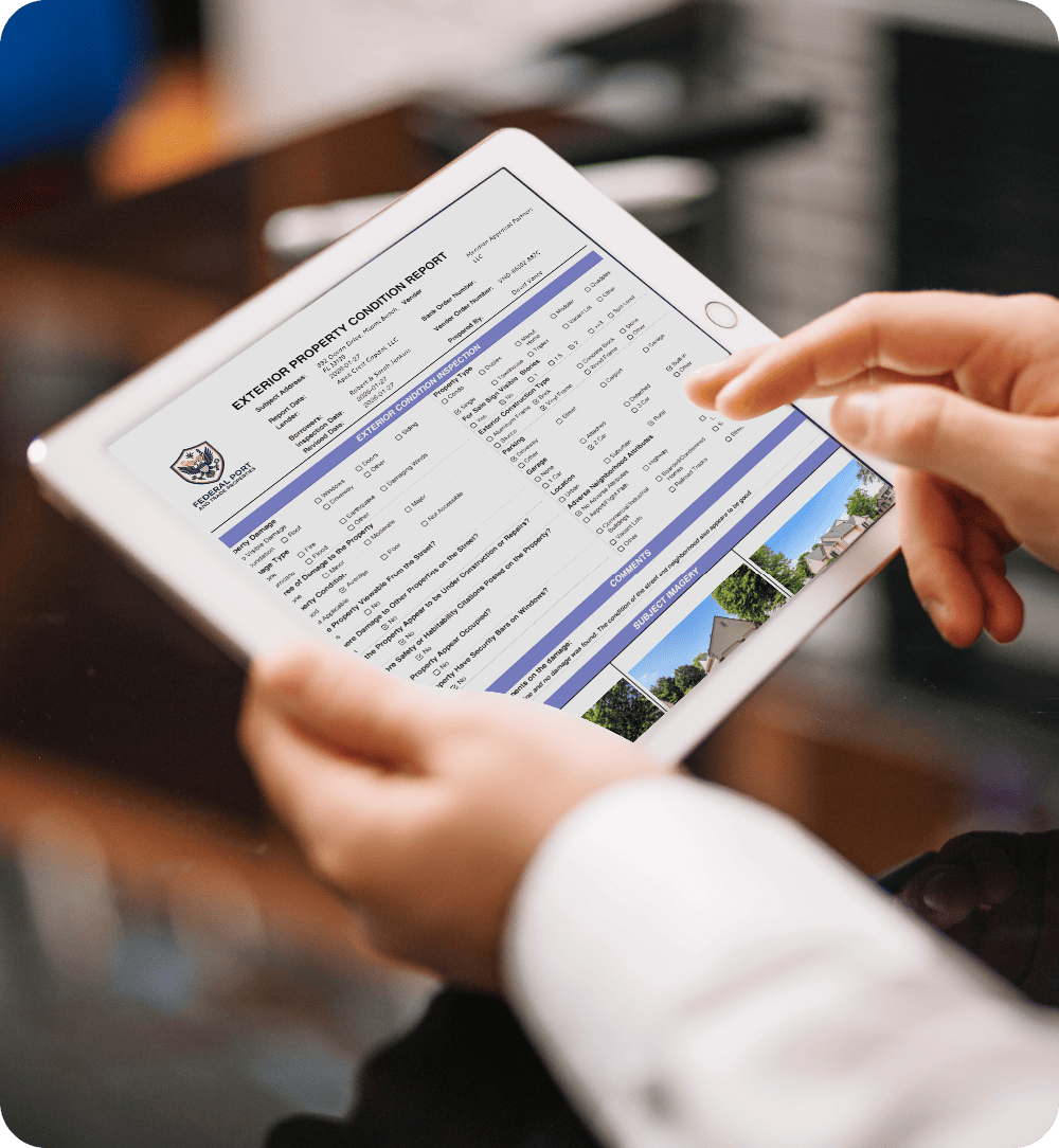 Field inspector reviewing an Exterior Property Condition Report on a tablet during a drive-by inspection